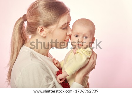 mother with newborn on her hands, kissing him