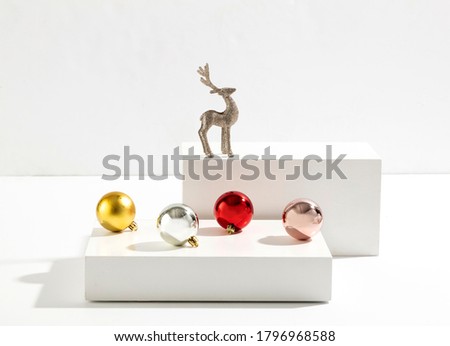 colorful christmas balls and deer on white cube. christmas background.