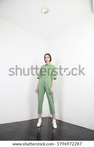 Fashion model beautiful woman wear casual style clothing for every day, light green cotton suit summer collection with white wall background studio accessory luxury.
