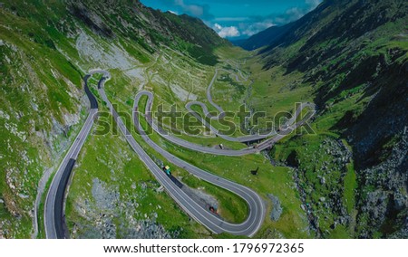 Epic winding road on Transfagarasan pass in Romania in summer time, with twisty road rising up. Road crossing Fagaras mountain range, noted as one of the best motorable roads in the world. Royalty-Free Stock Photo #1796972365