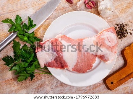 Close up of raw pork  on wooden surface with ingredients, nobody