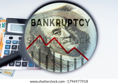 Bankruptcy of people and businesses. Falling graph under magnifying glass. Money and calculator. Concept bankruptcy law. Human bankruptcy court. Financial collapse. Failure from financial obligations