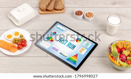 Organic food and tablet pc showing JUST RUN inscription, healthy nutrition composition