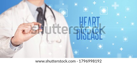 Close-up of a doctor giving a pill with HEART DISEASE inscription, medical concept