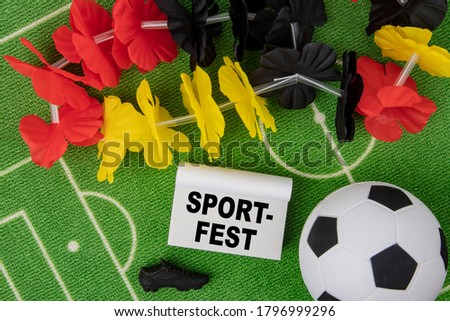 Sport Fest in german language means Sport Event. Soccer Ball with flower necklace in the colors of german flag and calendar