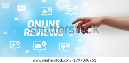 Close-Up of cropped hand pointing at ONLINE REVIEWS inscription, social networking concept