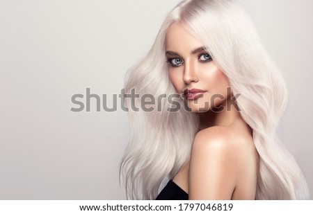 Beautiful girl with hair coloring in ultra blond. Stylish hairstyle curls done in a beauty salon. Fashion, cosmetics and makeup Royalty-Free Stock Photo #1797046819