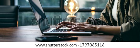 Young woman working with a laptop. Female freelancer connecting to internet via computer. Blogger or journalist writing new article. Close-up of female hands typing on keyboard Royalty-Free Stock Photo #1797065116