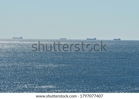 ships anchored in glistening ocean