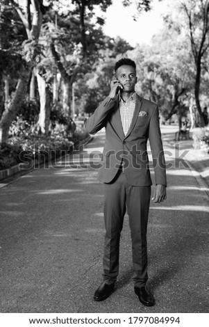 Young handsome African businessman relaxing at the park