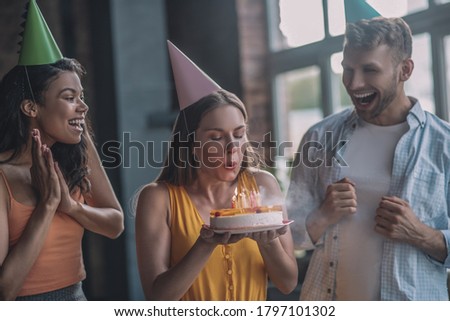 Moment of happiness. A woman blowing out candles on her birthday cake