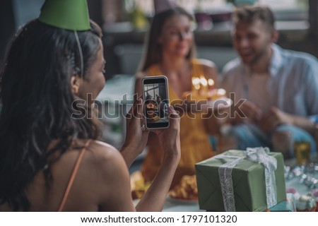 Shooting for social media. Friends taking pictures during the birthday party