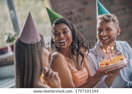 Birthday party. A woman holding a cake with candles during the birthday party