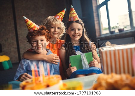 Birthday. Three friends in bday hats looking cheerful