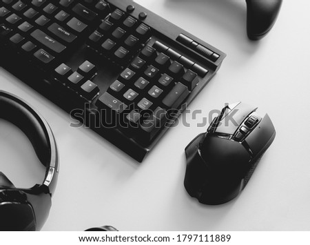 gamer work space concept with gaming gear, mouse, keyboard, joystick, headset on white table background.
