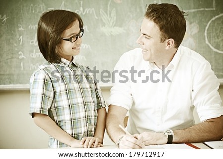 Cheerful kids at school room having education activity with teacher