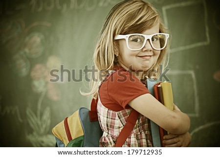 Cheerful colorized retro fashion little girl at school room having education activity