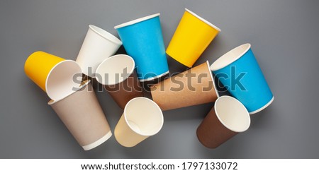 Set of colorful paper cups for coffee on a gray background. Top view