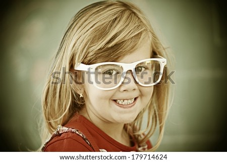 Cheerful filtered little girl at school room having education activity