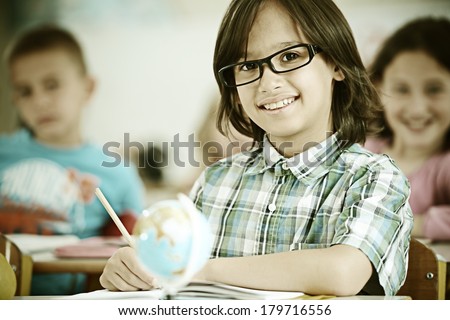 Cheerful kids at school room having education activity