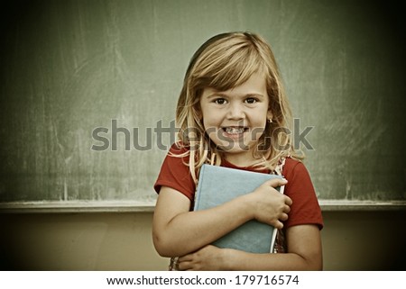 Cheerful kids at school room having education activity on chalkboard