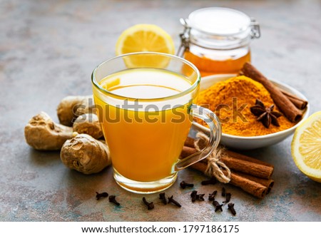 Energy tonic drink with turmeric, ginger, lemon and honey on a grey concrete background Royalty-Free Stock Photo #1797186175