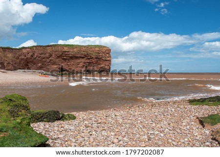 Landscape photo of the the mouth of the Otter estuary flowing into the sea on Budleigh Salterton beach