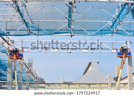 Steel structure roof truss frame installation by mobile crane under the construction building in the factory