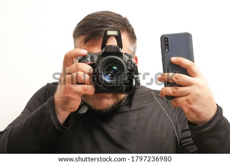 press photographer with a professional camera and mobile cell phone . Isolated on white background. no face. paparazzi man. built-in flash.