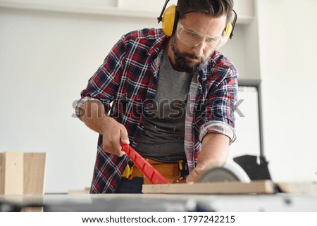 Carpenter cutting wood on a circular saw                               
