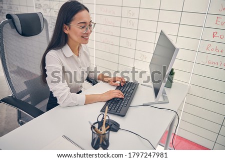 Pretty longhaired office worker expressing positivity while spending her break during online conference