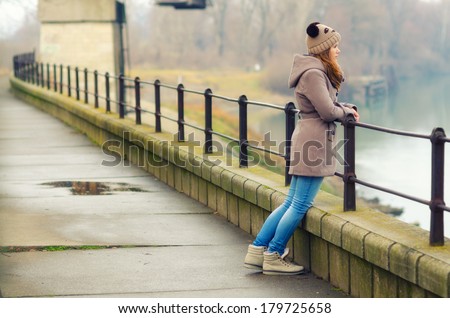 Sad teenage girl standing outside on cold winter day. Royalty-Free Stock Photo #179725658