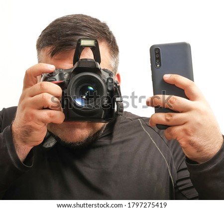 press photographer with a professional camera and mobile cell phone . Isolated on white background. no face. paparazzi man. 
