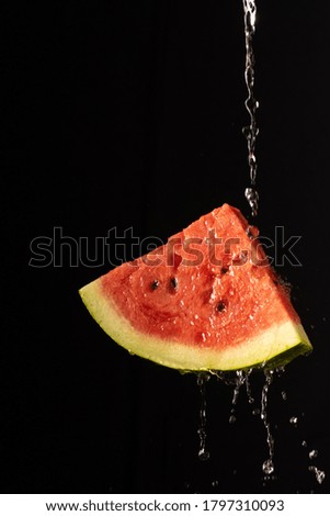 Watermelon with a beautiful splash of water with black background and selective focus.