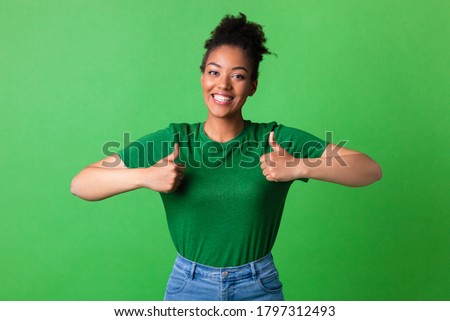 Everything Is Great. Portrait of happy african lady making thumb up gesture standing at green studio background
