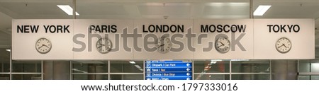 five white international clock with different time zone hanging on banner in airport station front view