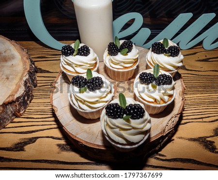 delicious fresh homemade organic muffins decorated with blackberries and cream. Delicious sweets for a holiday,