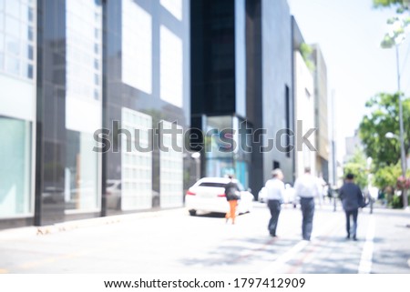 Blurred background of asian people, businessman walking on sidewalk and traffic on the road with business building, business area in the city, Seoul Korea, perspective.