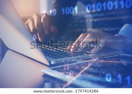 Agile digital software technology development, IoT concept. Man programmer, software developer working on digital tablet and laptop computer with smart city with binary, html computer code on screen