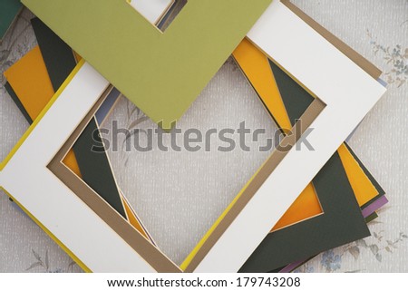 Picture mat boards hang in a cluster on a wall. Royalty-Free Stock Photo #179743208