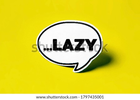 LAZY speech bubble on white paper isolated on yellow paper background with drop shadow. COPY SPACE.