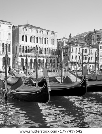 Black and white view of The Grand Canal in Venice with moored gondolas, Italy 