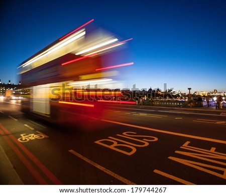Double-Decker bus crossing Westminster Bridge at night in London, England