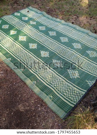 patterned green mat on the earthen background