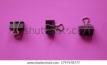 Black Binder clip on pink background