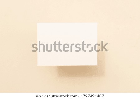 summer stationery mock-up scene. Blank business card on beige textured table background. Flat lay, top view