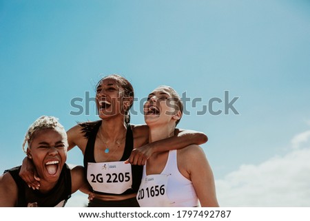 Young team of female athletes standing together and screaming in excitement. Diverse group of runners enjoying victory. Royalty-Free Stock Photo #1797492787
