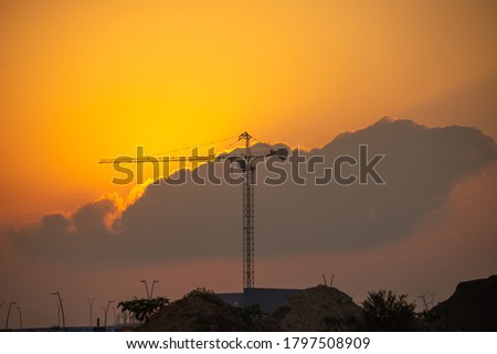 Tower crane at a construction site at sunrise.