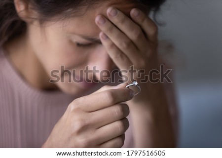 Close up of upset young woman hold wedding ring disappointed with marriage dissolution, unhappy sad millennial Caucasian female suffer after cheating or breakup, frustrated with relationships problems