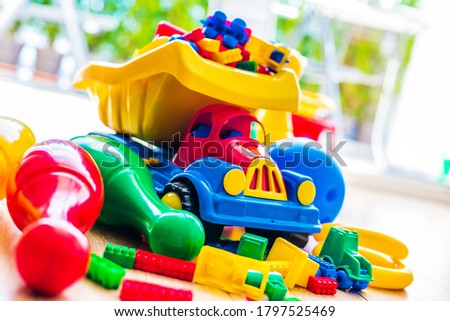 Colorful plastic children toys on the floor.
